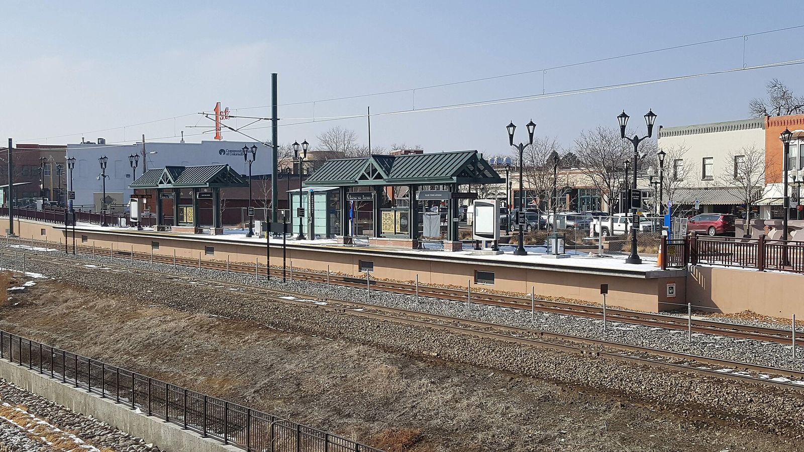 Olde Town Arvada commuter rail station platform and shelters seen across the tracks