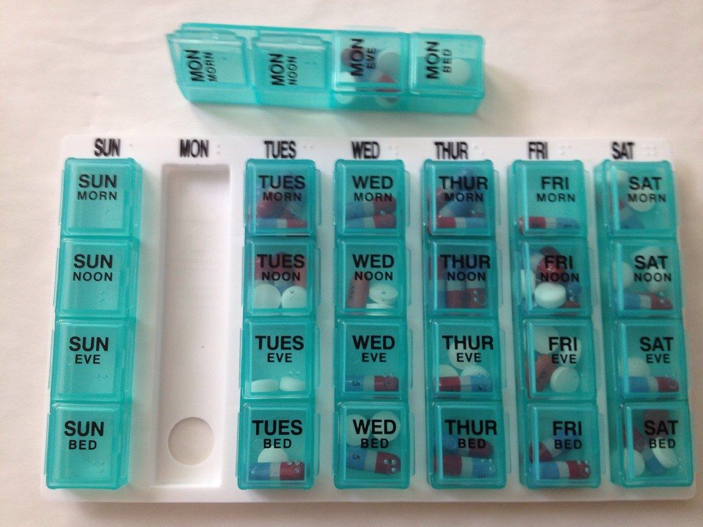 Teal weekly pill organizer with compartments for each day and time of day