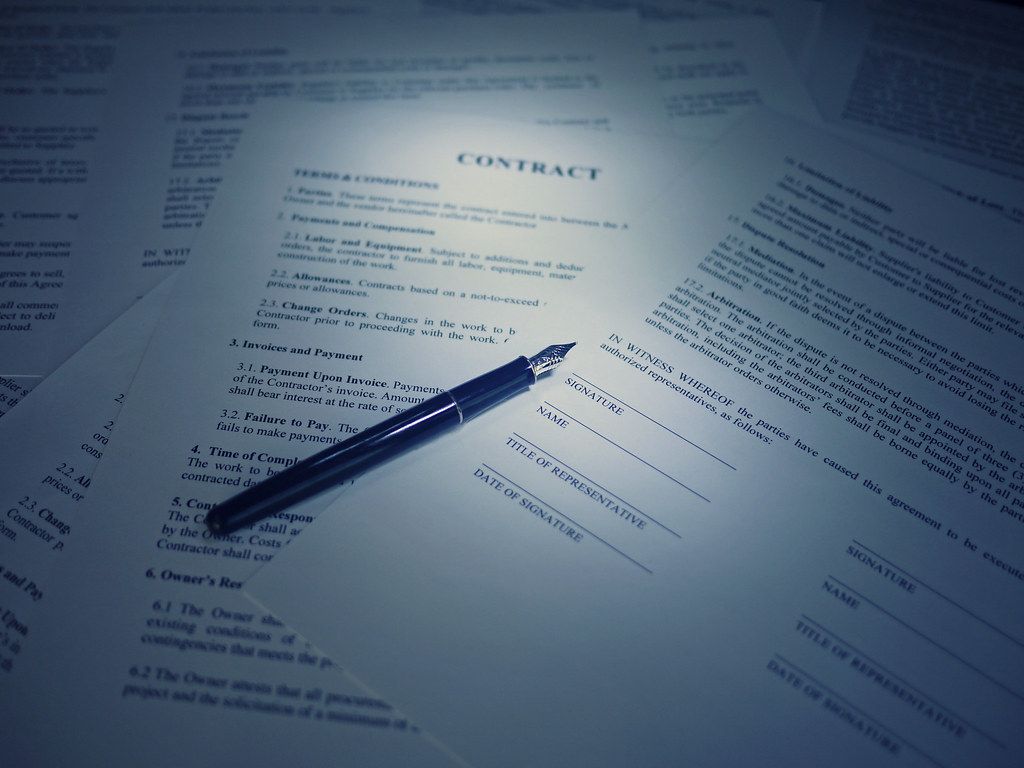 Printed document with a fountain pen resting across the page in cool blue light