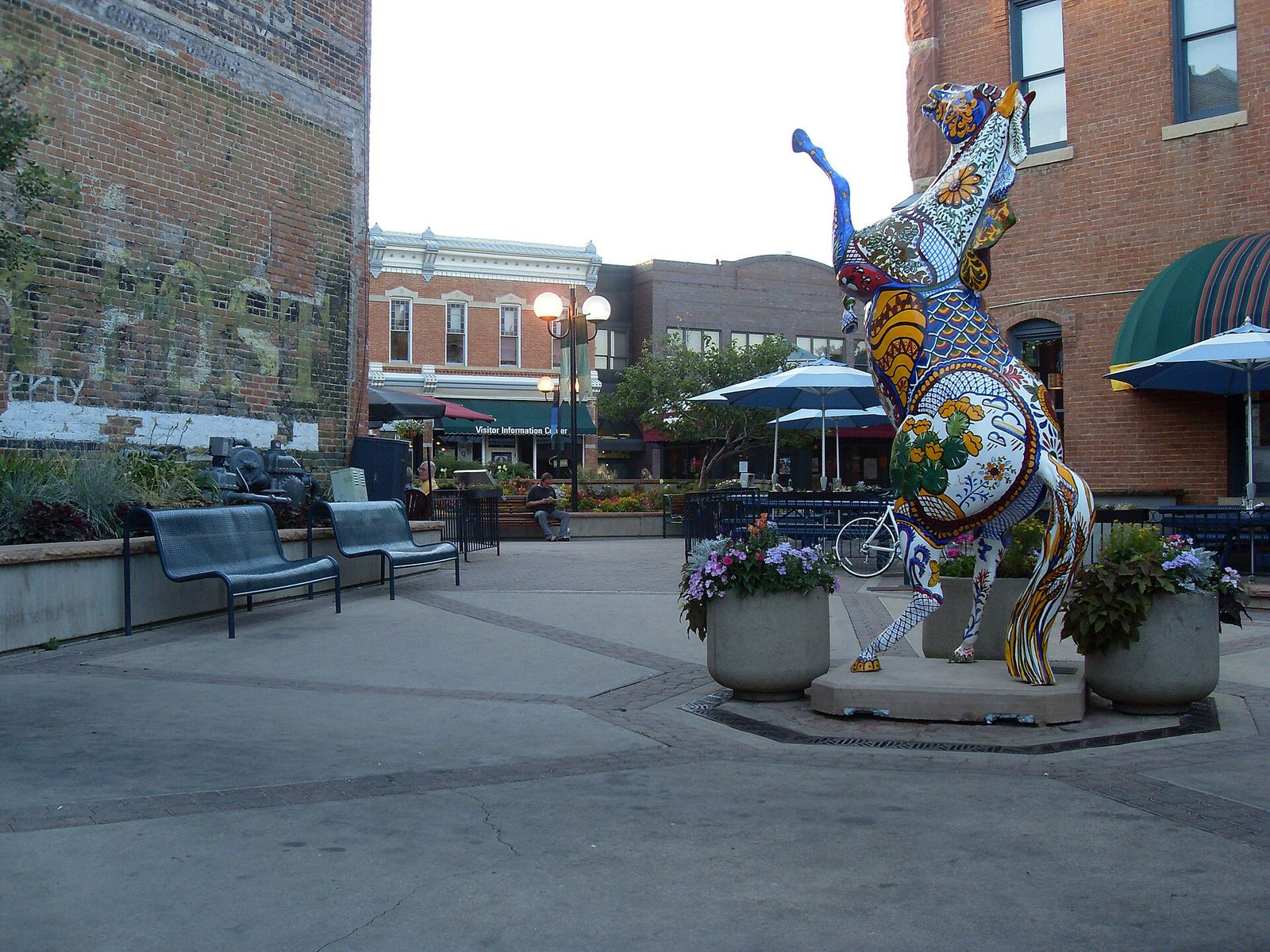 Old Town Square in Fort Collins with a painted horse sculpture, benches and historic storefronts