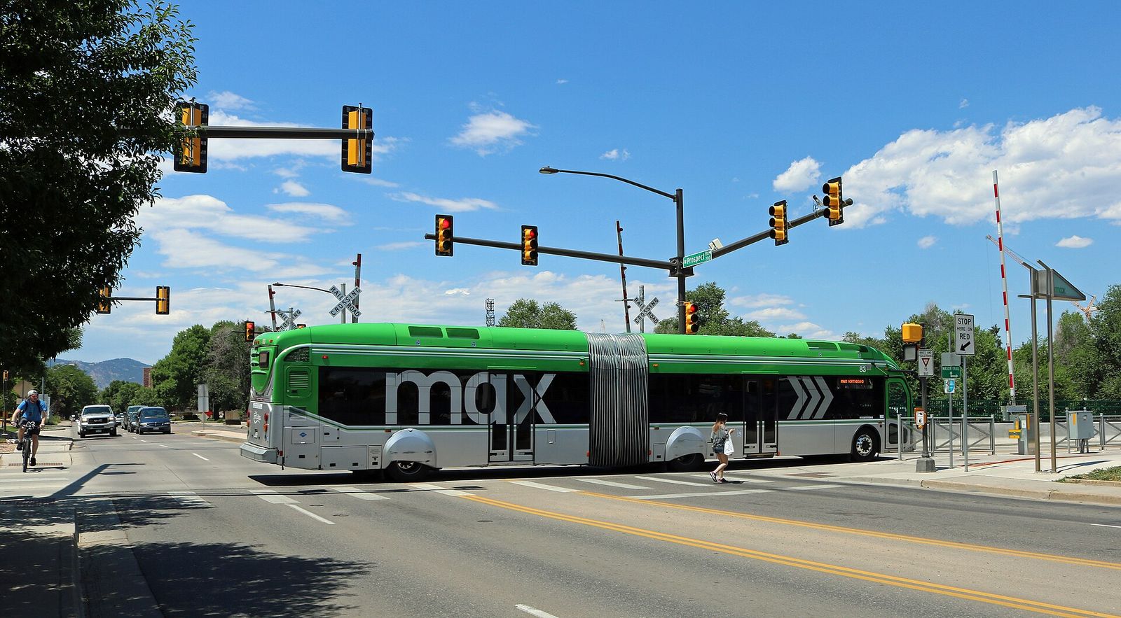 Green Transfort MAX bus crossing an intersection at West Prospect Road in Fort Collins
