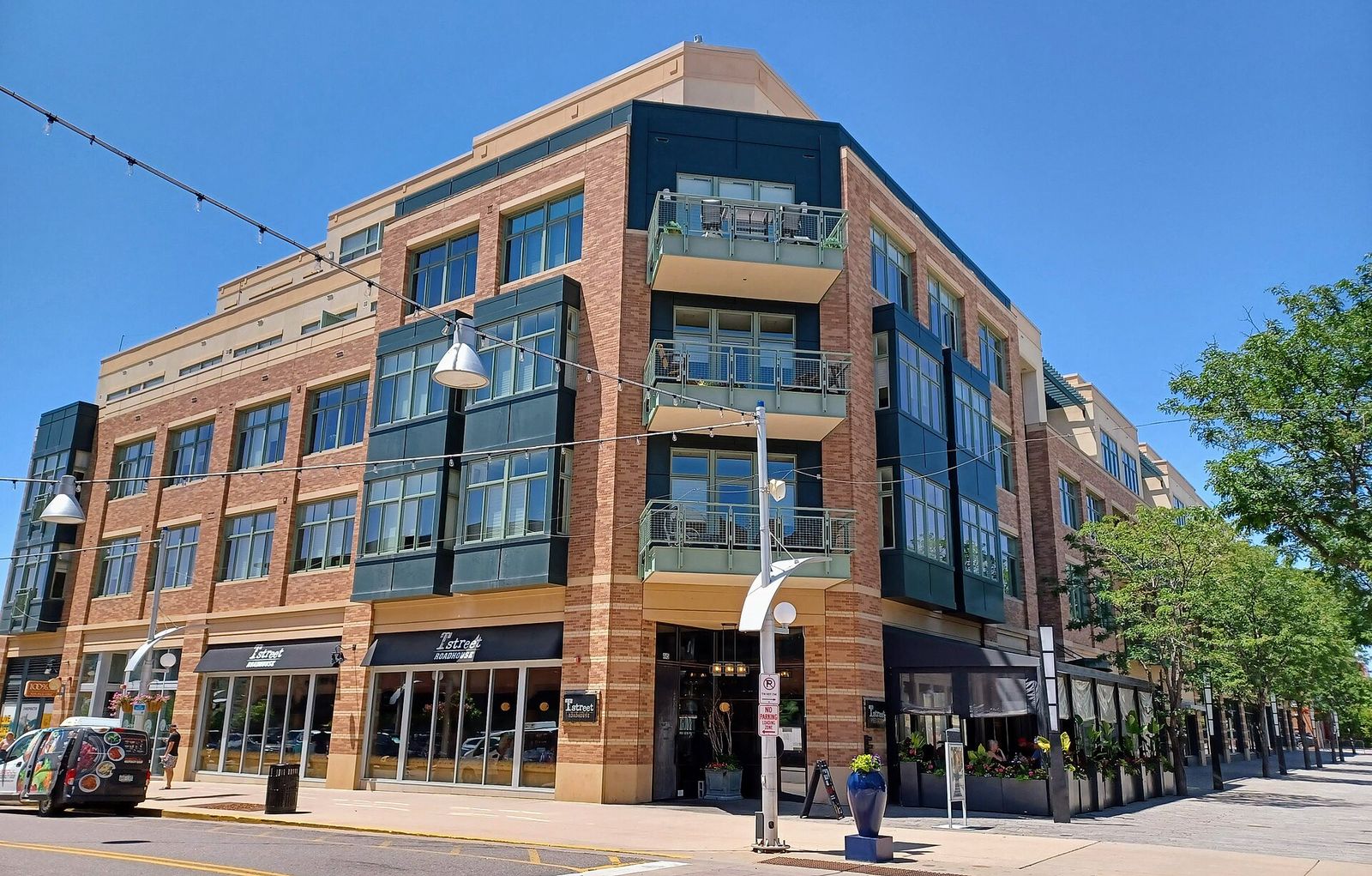 Brick mixed-use building with apartments above street-level businesses at Belmar in Lakewood