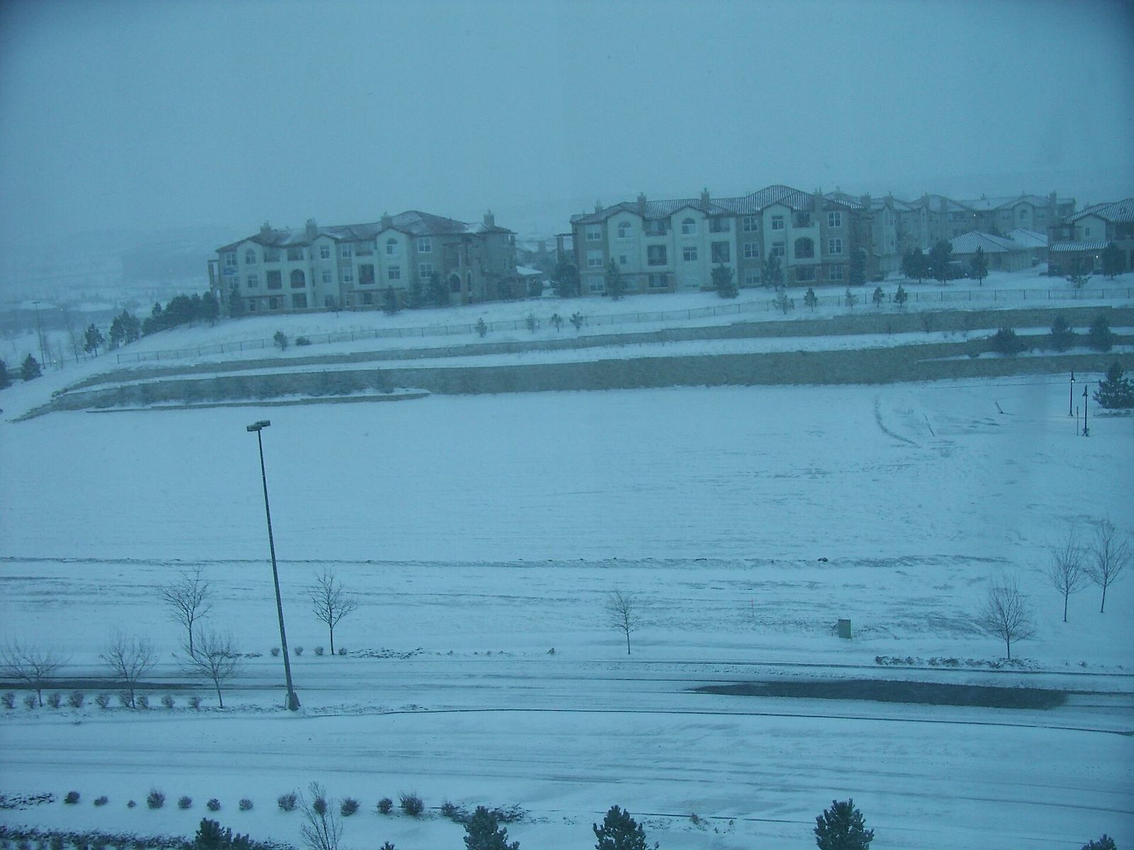 Apartment complex buildings in Broomfield, Colorado seen across a snow-covered open field