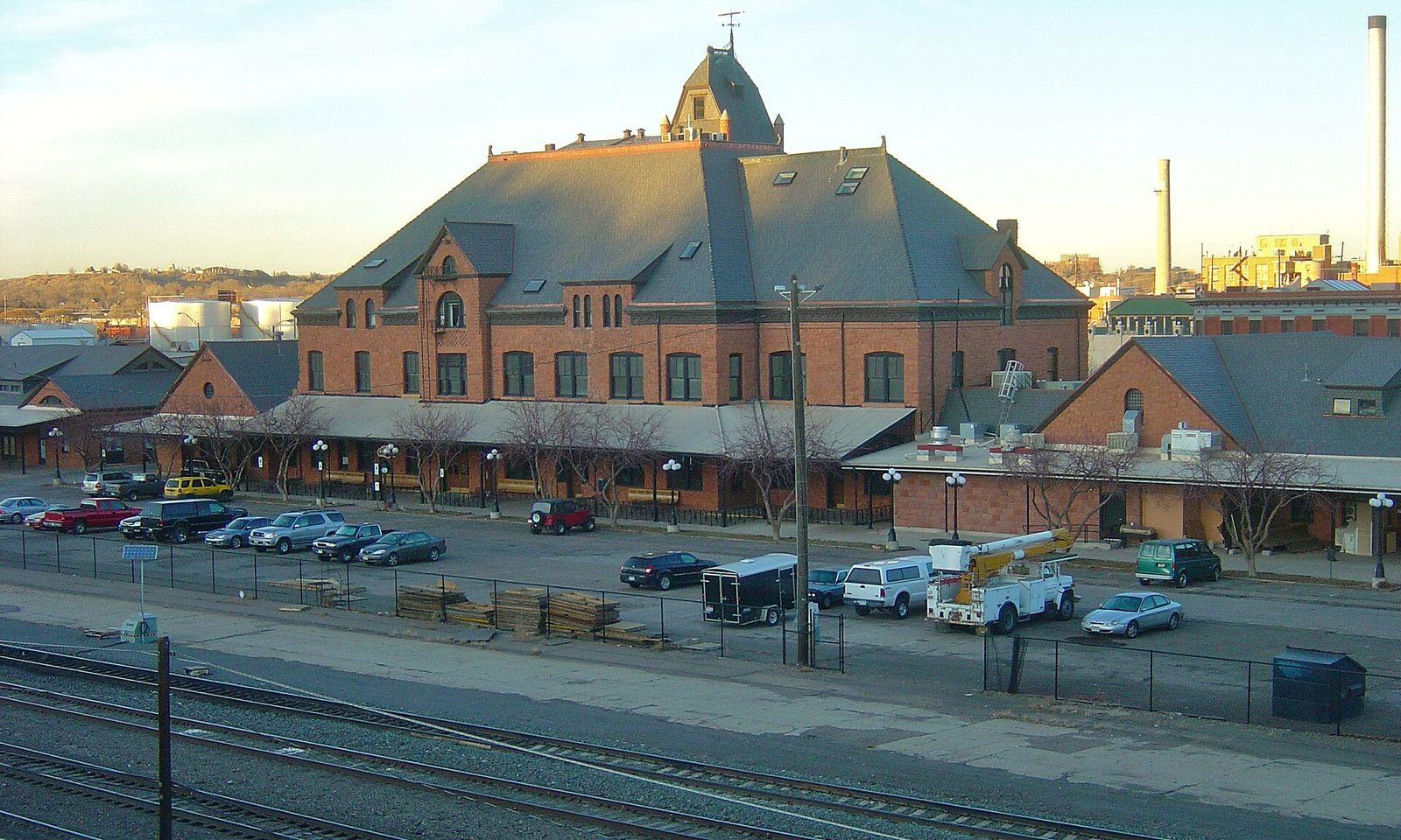 Historic red sandstone Pueblo Union Depot with its tower and a parking lot in front