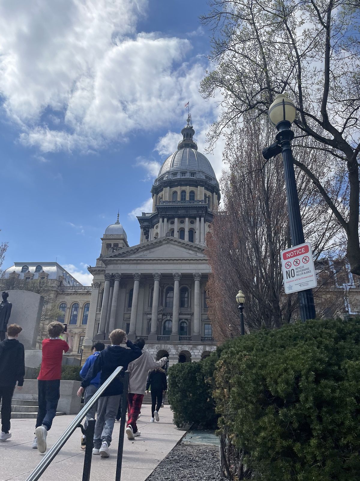 Illinois State Capitol dome in Springfield seen from a walkway lined with trees
