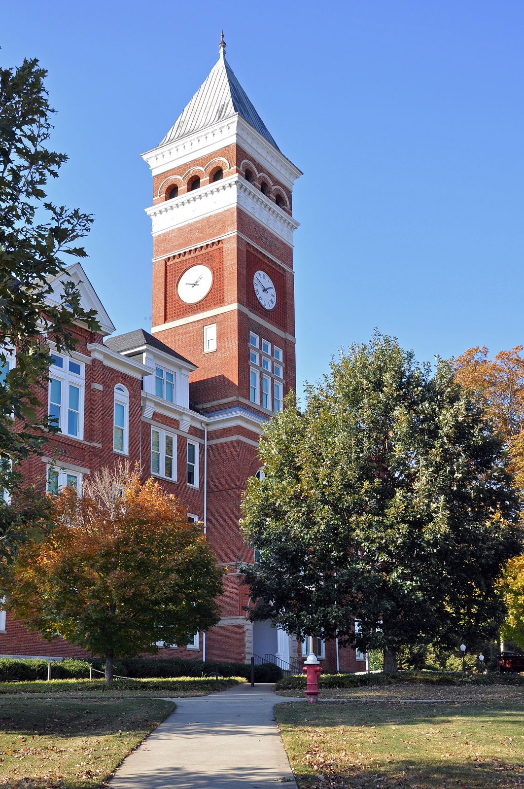 Clock tower of Tillman Hall at Clemson University framed by autumn trees