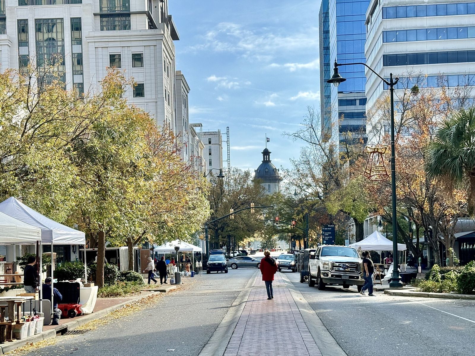 Main Street in Columbia lined with market tents, with the South Carolina State House dome at the end