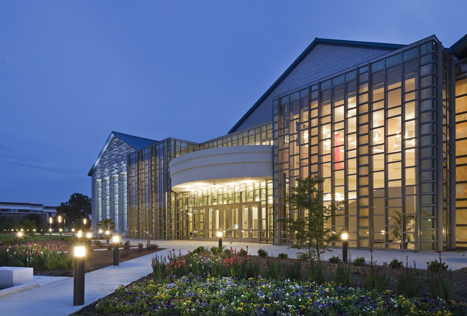 Glass facade of the Francis Marion University Performing Arts Center in downtown Florence at dusk