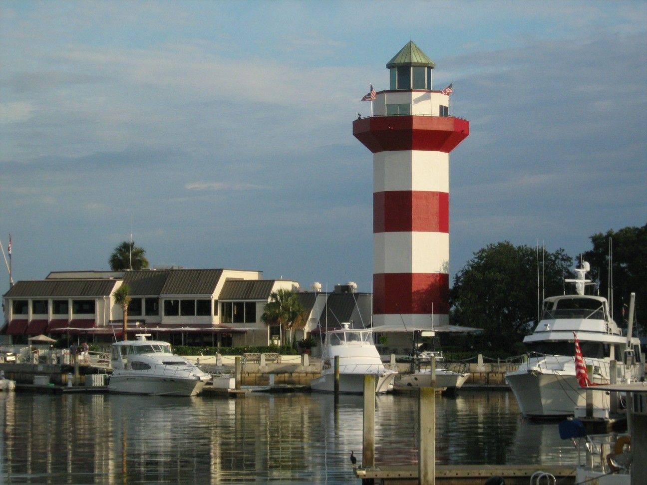 Red and white striped Harbour Town lighthouse above boats in the marina