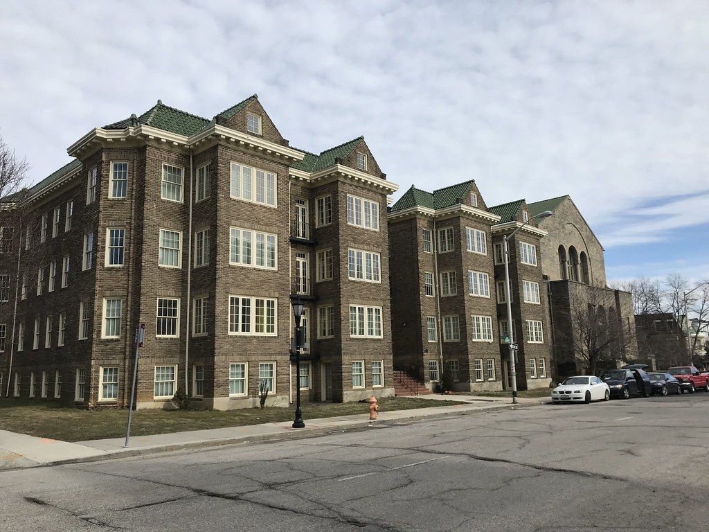 Four-story brick condominium building with bay windows on a street corner