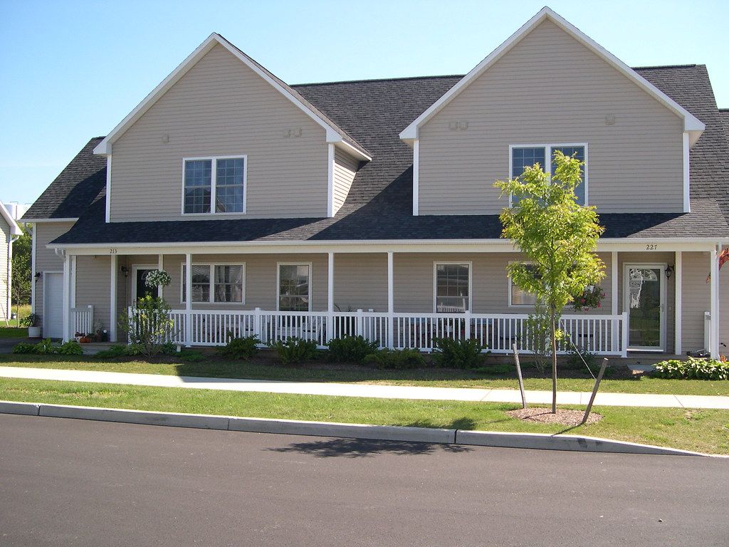 Two-story duplex with twin gables and a long front porch
