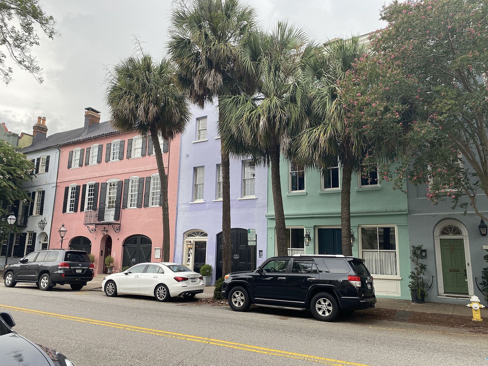 Pastel row houses of Rainbow Row on East Bay Street in Charleston under palmetto trees
