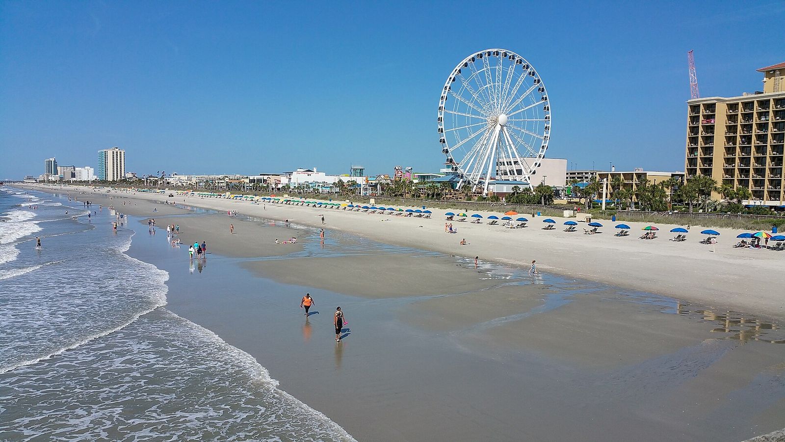 Wide sandy beach at Myrtle Beach with the SkyWheel and oceanfront hotels in the distance