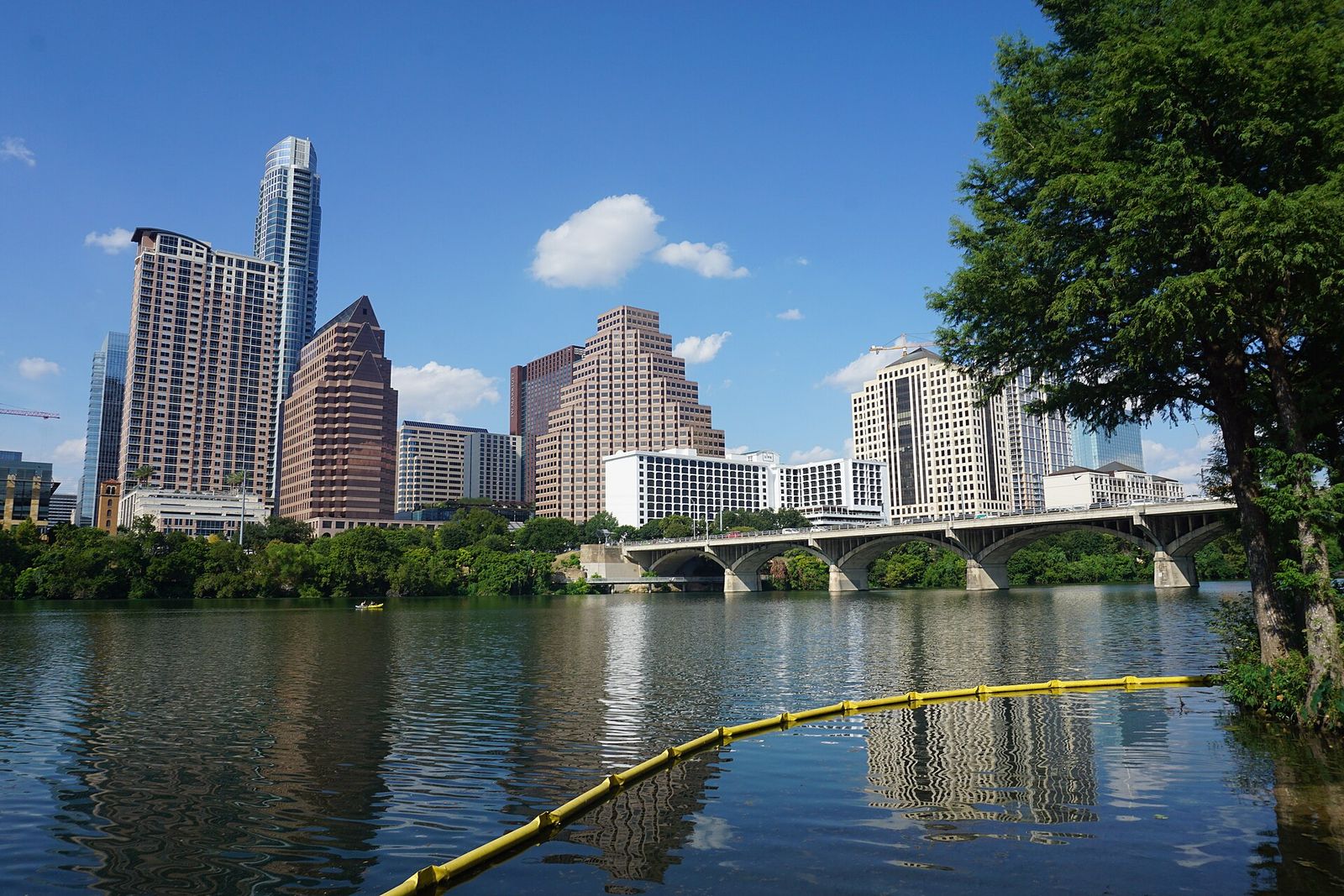 Downtown Austin skyline reflected across Lady Bird Lake on a clear summer day