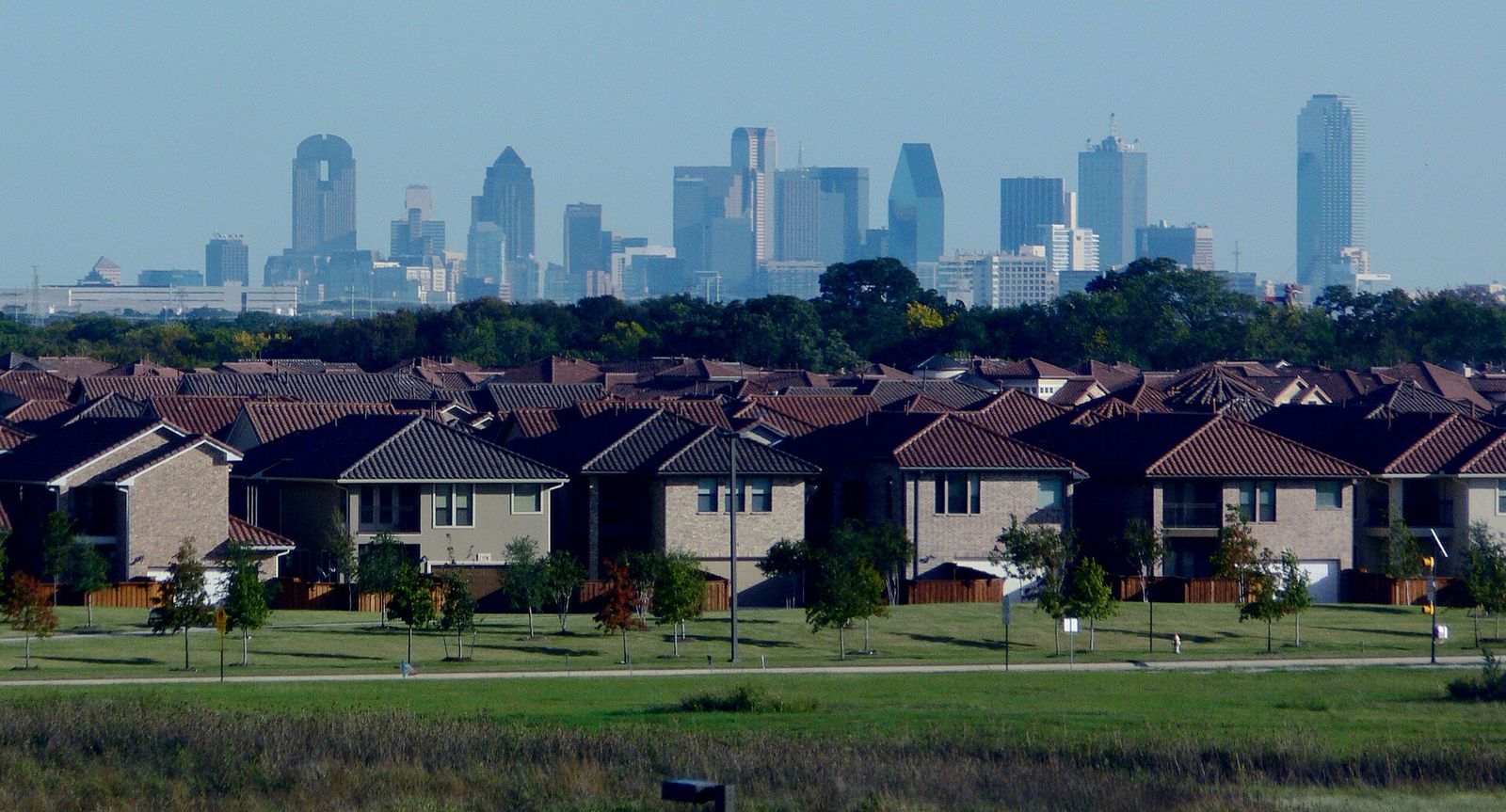 Rows of suburban homes with the Dallas skyline on the horizon
