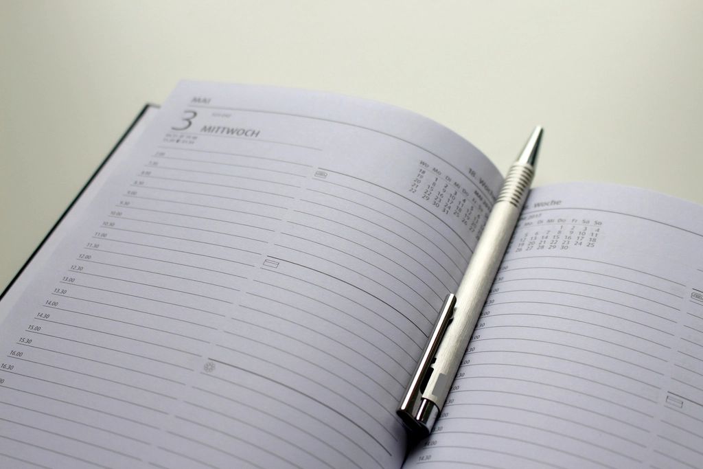 Open weekly planner with a silver pen resting on the page
