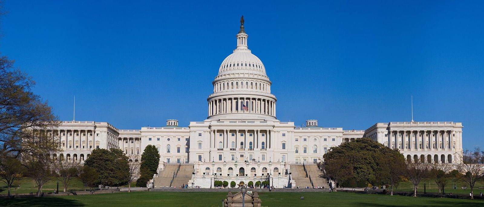 United States Capitol building with its dome and lawn under a blue sky