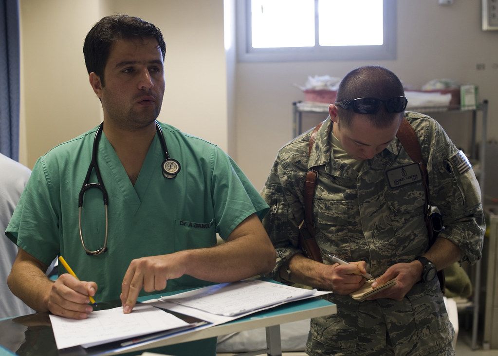 Clinician writing notes on a clipboard at a desk
