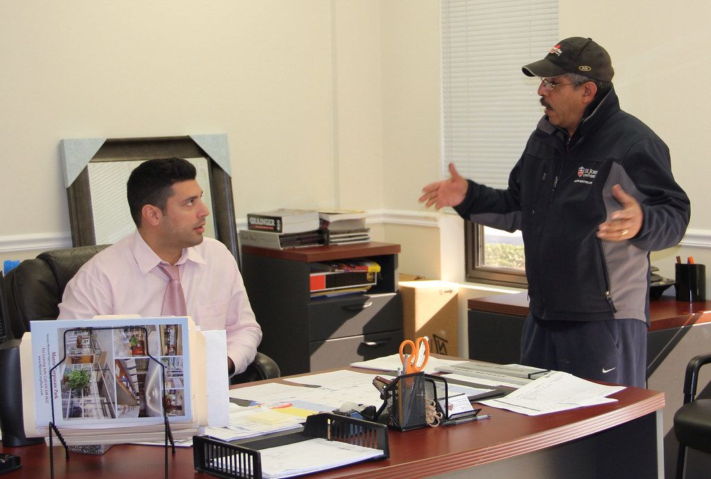 Property manager at a desk talking with a resident in an on-site office