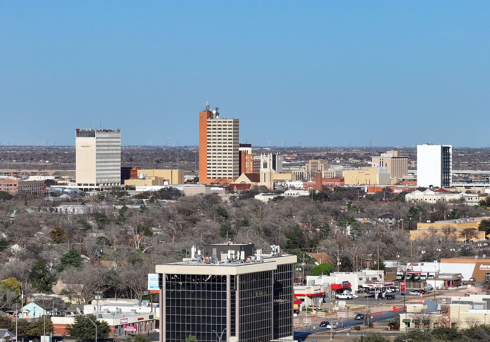 Lubbock skyline rising above tree-lined neighborhoods on a clear day