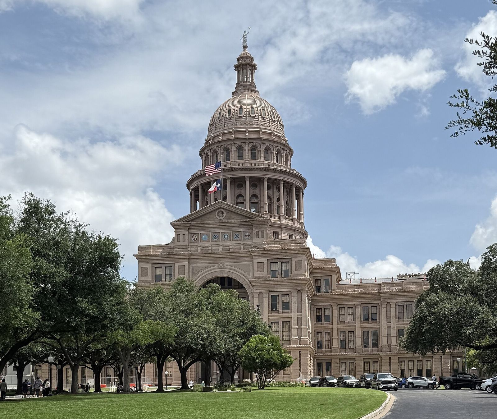 Texas State Capitol dome in Austin framed by live oak trees