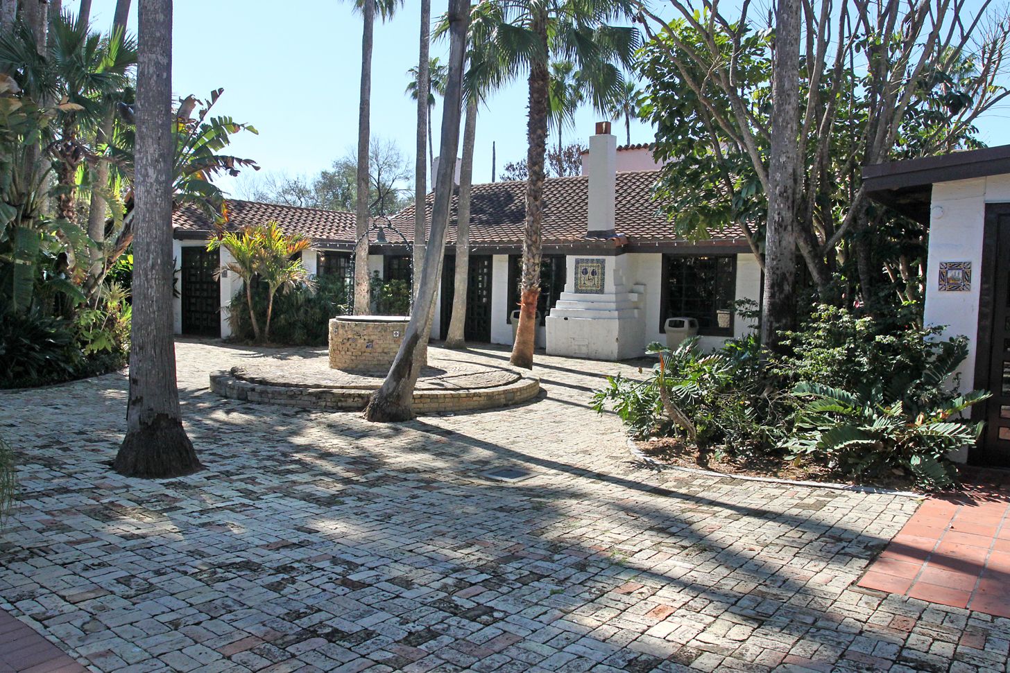 Shaded brick courtyard with palms and a fountain at Quinta Mazatlan
