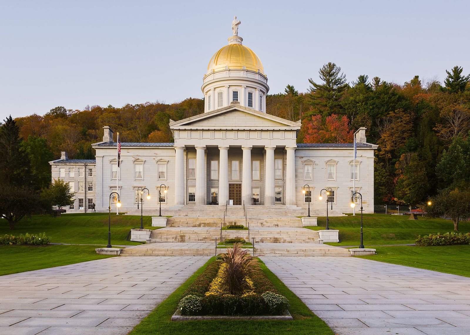 Vermont State House in Montpelier with its gold dome against autumn hills