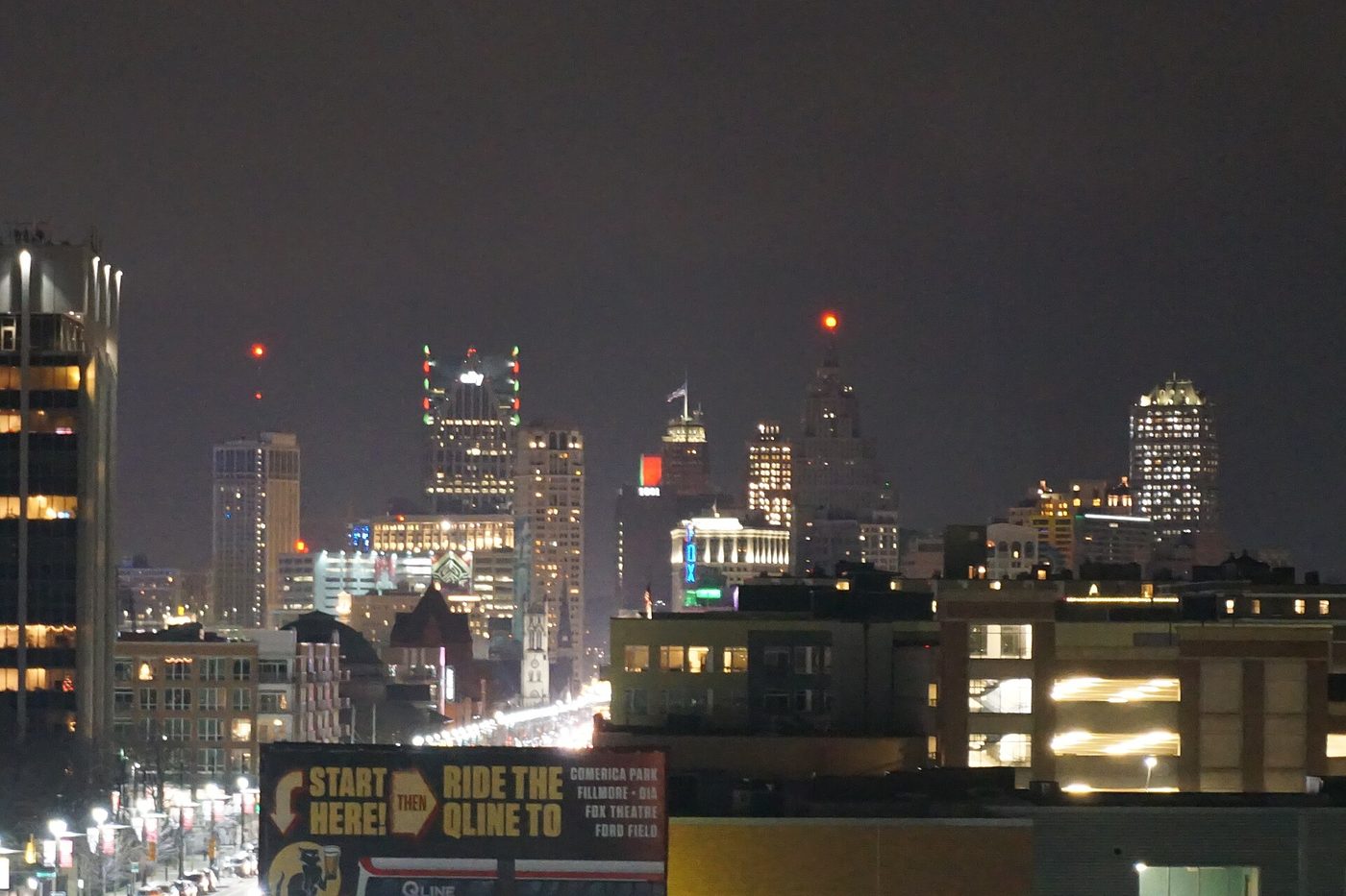 The Detroit skyline lit at night above the surrounding streets
