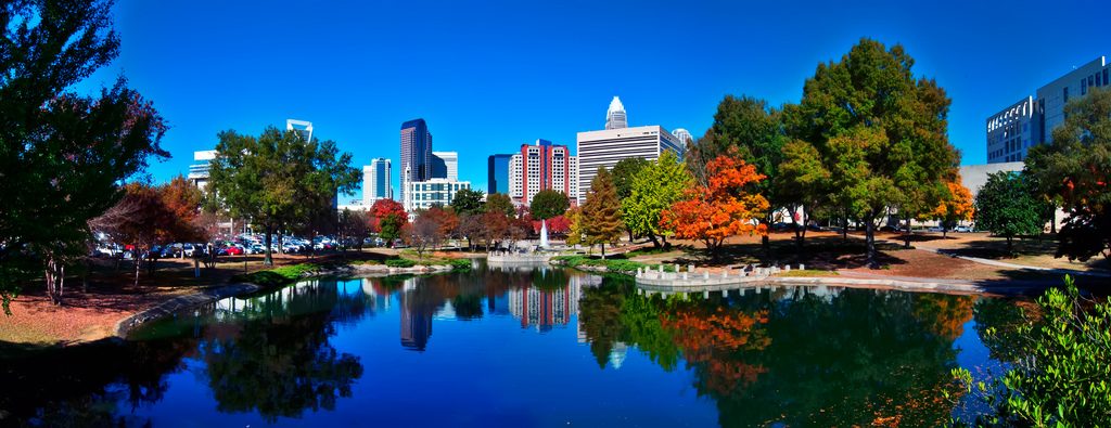 The Charlotte skyline reflected in a park lake in autumn